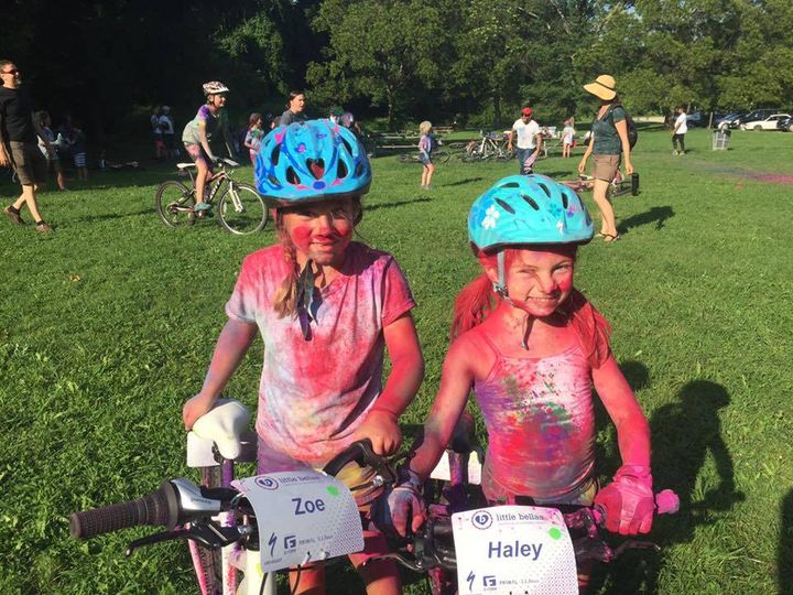 Two girls wearing helmets and paint on bikes

Description automatically generated